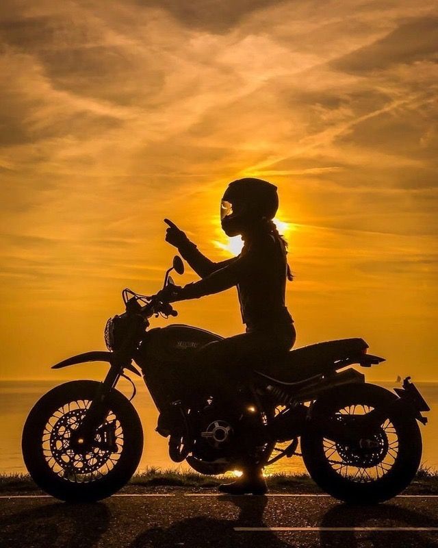 Donna in moto al tramonto